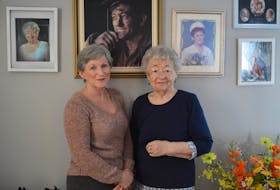 Joanne Shepard, left, stands with her mother Theresa Young in their Glace Bay home in February. Above them a picture of Shepard’s father and Young’s widow, Fabian Young, who died during the mine explosion at No. 26 colliery in 1979.