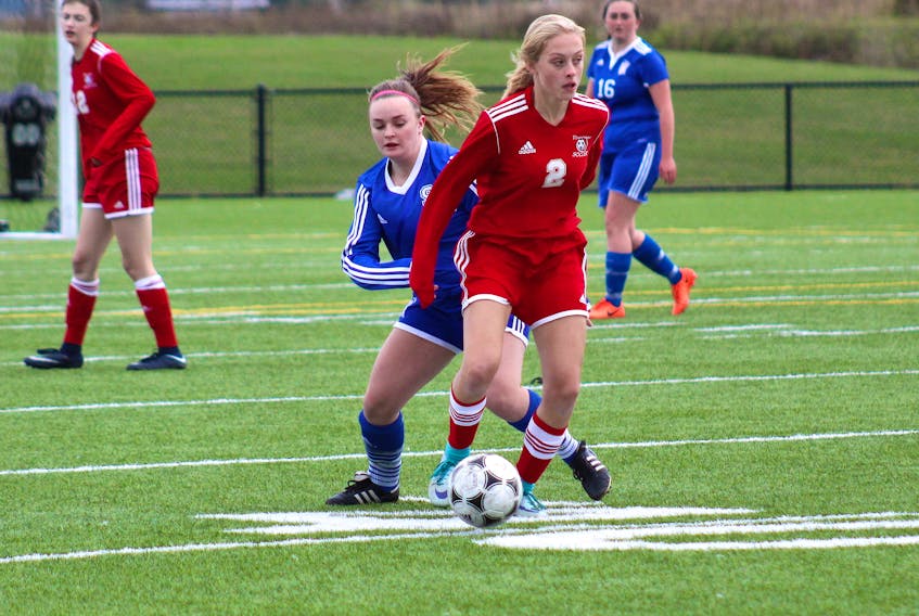 Riverview High School defender Julia Mombourquette, right, keeps the ball away from Sydney Academy striker Katie Hasiuk as the Reds took on the Wildcats in Cape Breton High School Soccer League action at Open Hearth Park in Sydney on Wednesday. Riverview won the game, 9-0.