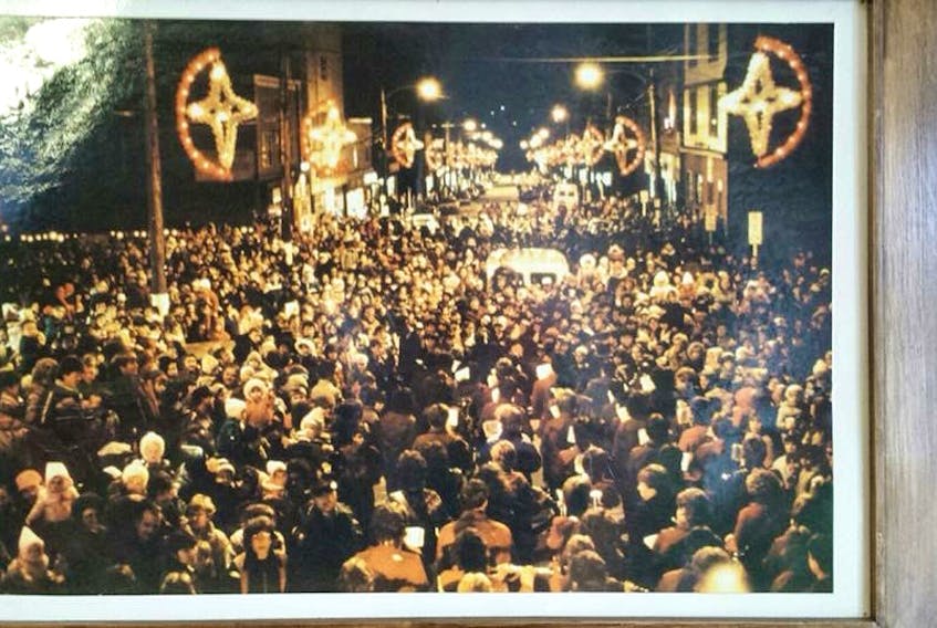 A photo of a picture hanging inside AA Munro Insurance on Reserve Street in Glace Bay, taken during a light up ceremony on Commercial Street in Glace Bay in 1983. A ceremony is being held tonight from 6-8 p.m. and organizers from #bayitforward are hoping to recreate this photo by filling Commercial Street at 7 p.m.