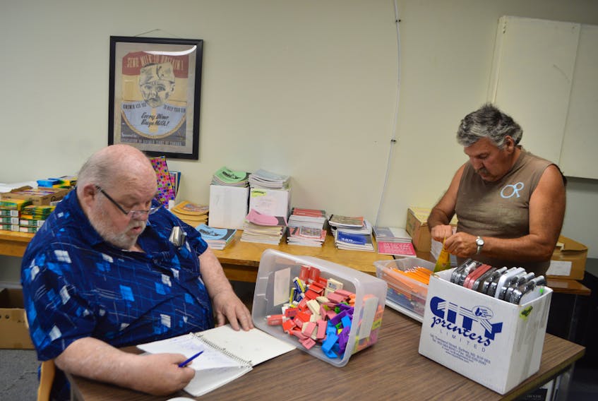 Angus Gillis, left, and Andrew Digero, members of the New Waterford Kinsmen Club, sort through supplies for the annual Ida and Martin Schwartz Memorial Back to School program. The Kinsmen are accepting donations for the program and anyone wishing to register for assistance must do so by Thursday.