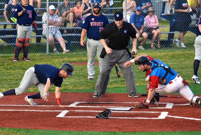 In this file photo, Chris Farrow, left, of the Sydney Sooners scrambles to get home after missing the plate as catcher Greg MacKinnon, right, of the Halifax Pelham Molson Canadians looks for the overthrown ball during Nova Scotia Senior Baseball League action at the Susan McEachern Memorial Ball Park in Sydney last July. The senior baseball league will feature four teams this year, as the Truro Bearcats won’t be able to field a club this summer.