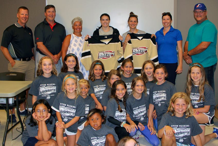 Nova Scotia hockey players and Olympic silver medallists Blayre Turnbull and Jill Saulnier model the new Cape Breton Blizzard hockey program jerseys during a skills camp for female hockey players at the Membertou Sport and Wellness Centre on the weekend. A group of camp attendees sit and kneel in the foreground, while the back row from left to right are: Peter McCarron of Dairy Queen, Sydney River, Rob Clemons of Dairy Queen, Grand Lake Road, Judi McCarron of Dairy Queen, Sydney River, Turnbull, Saulnier, Christina Lamey of the Cape Breton Female Hockey Committee and James Edwards of Glace Bay Minor Hockey.