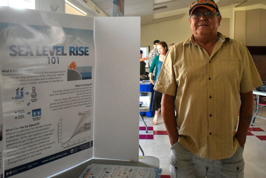 Andrew Lafford, from Eskasoni, stands by a display at Sunday’s open house on rising water levels in the Bras d’Or Lakes put on by the Ecology Action Centre.