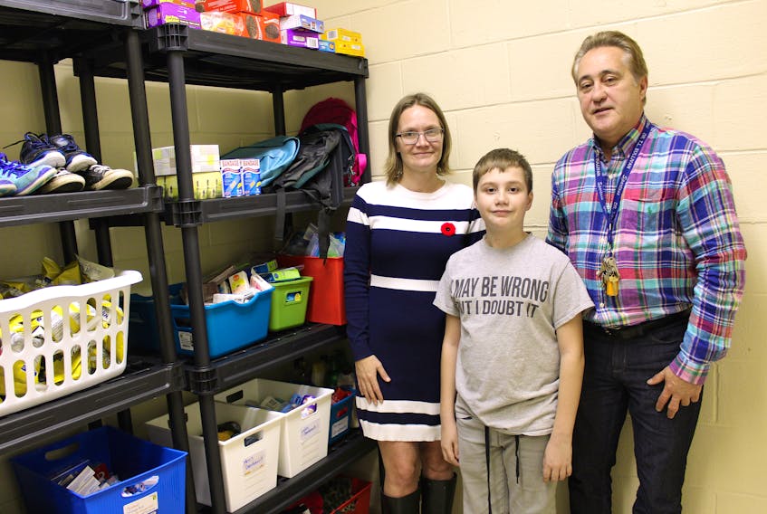 Mother of two Lisa Bond, left, her 12-year-old son Zavier Bond, and Dr. T.L. Sullivan principal Charles Yorke stand inside the newly established Care Closet located in a room adjacent to the school’s guidance office.