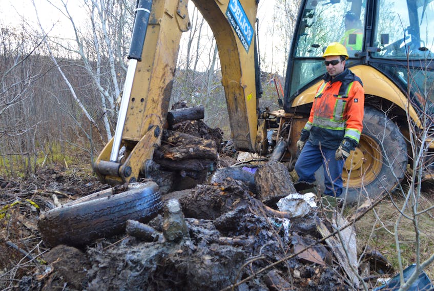 Paul Dalesandro, owner of Delio’s Property Maintenance Services Ltd., checks out some of the trash pulled out of some brush while working on a cleanup of an illegal dumping area on land owned by the Cape Breton Regional Municipality near the Jonathan Skeete Memorial Ballfield on Tupper Street in Whitney Pier.