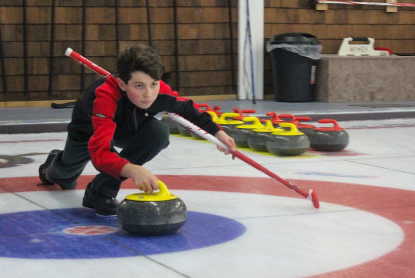 Evan Penney prepares to release a rock during a session of the Alpha/Junior curling program on Monday, Oct. 29, at the Sydney Curling Club.