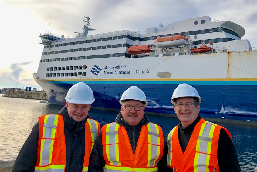On a January visit to Port aux Basques, N.L., from the left, Murray Hupman, vice-president operations for Marine Atlantic, met with new board members Gary O’Brien and Owen Fitzgerald. In the background is the MV Highlanders at dock in Port aux Basques.