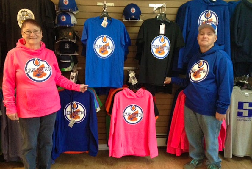 Breton Ability Centre clients and Best of Cape Breton Gift Shop employees Shirley MacLean and Glen Hannon proudly display a range of Cape Breton Oilers merchandise now available at the downtown Sydney store. The shop is a social enterprise of the centre and all profits are put back into providing quality services and supports to people of varying disabilities.