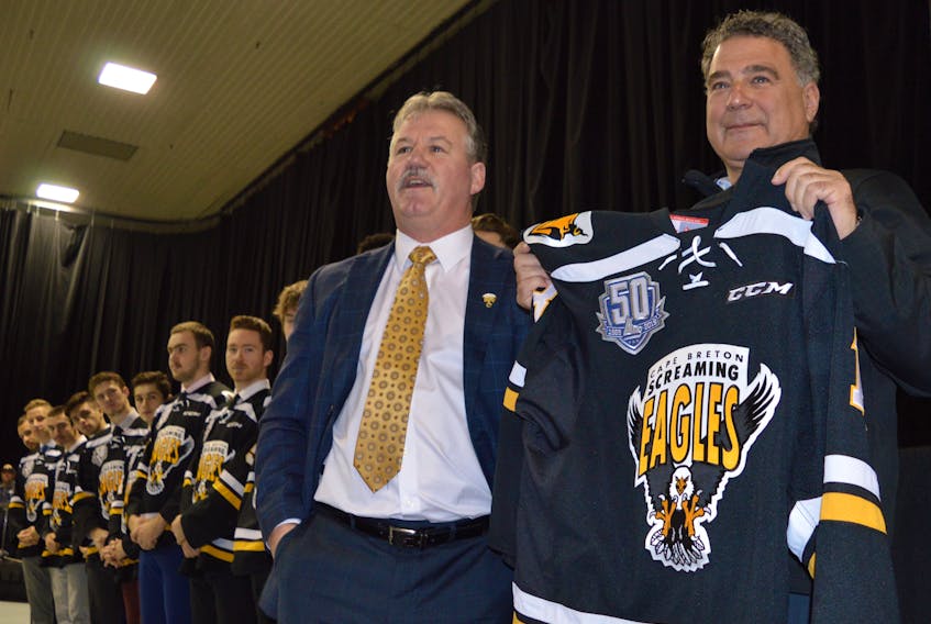 Irwin Simon, right, was presented with his first Cape Breton Screaming Eagles jersey by team president Gerard Shaw, left, during a press conference to announce his majority ownership in the team at Centre 200 on Tuesday. Simon will own about 70 per cent of the club.
