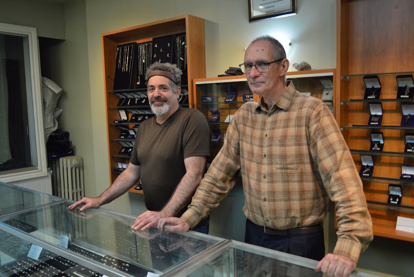 Michael Alteen, right, and his employee Glen O’Neil are seen standing at the counter of Alteen’s Jewellers in Sydney. The business will close Friday as Michael Alteen retires after 55 years working at the store.