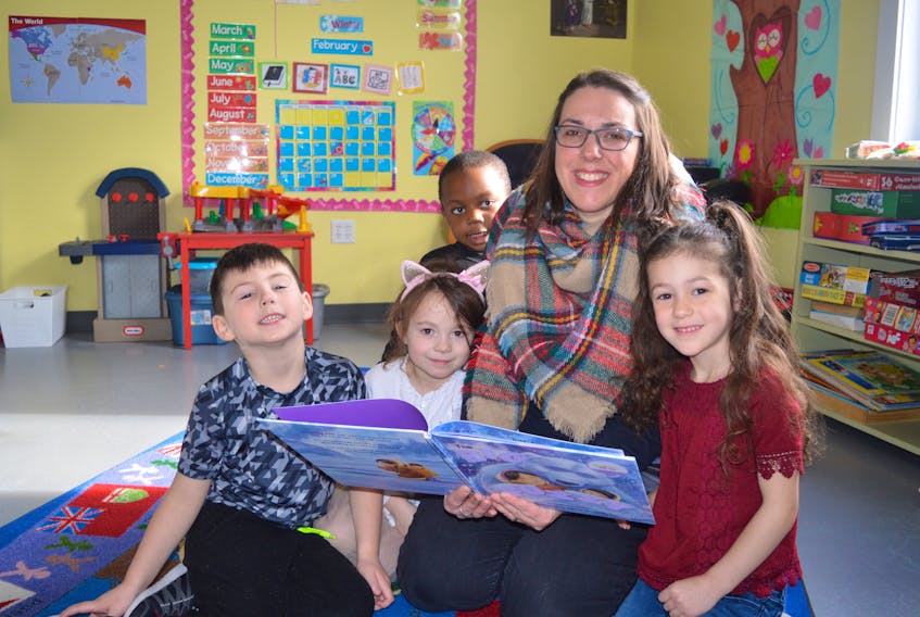Primary students at Munro Academy in Balls Creek are shown reading a book with teacher Mary Jane Murphy during recess at the local school, Tuesday. From left, Eric Joseph, Lucy Brake, Temi Osunneye, Murphy and Priya Joseph.