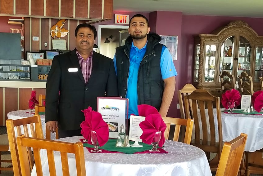 Maqbool (Mack) Bhatti, left, and his son, Ali Bhatti, pose for a photo in the new restaurant that opened at the Trailsman Motel in Nyanza, Victoria County, on Sunday. The Bhattis have spent approximately $500,000 in renovations on the motel.