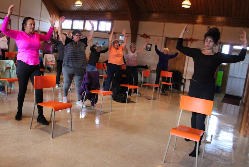 Vicky McNeil, right, guides a chair yoga class at Warden United Church in Glace Bay last November. The certified yoga teacher is also a Canfitpro (personal trainer) and a healthy eating coach. The yoga classes she holds at Warden have become so popular, a second session has been added.