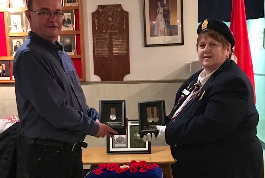 Martin Campbell, left, from Hay River holds a First World War medal that belonged to his great-uncle Peter Roderick Campbell at the Royal Canadian Legion Branch 12 Sydney on Jan. 10, given to him by Ann Mischiek, right, originally from Wreck Cove but now living in Sydney.