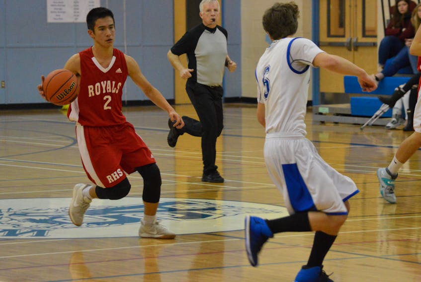 Coby Tunicliff of the Riverview Royals, left, takes the ball past half as Sydney Wildcats player Jarrett Wilson plays defence during the regular-season opener for both teams in the Cape Breton High School Basketball League at Sydney Academy on Tuesday. Sydney Academy won, 98–58. (CHRISTIAN ROACH/CAPE BRETON POST)