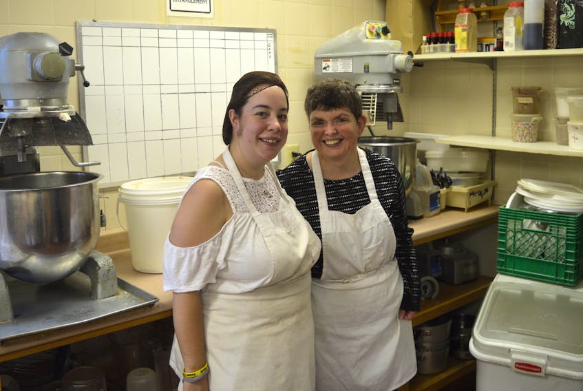 Caitlin Cox, left, and Dana Farrell stand in the bakery of the Horizon Achievement Centre. The two are longtime clients and workers at the centre. (CHRISTIAN ROACH/CAPE BRETON POST)