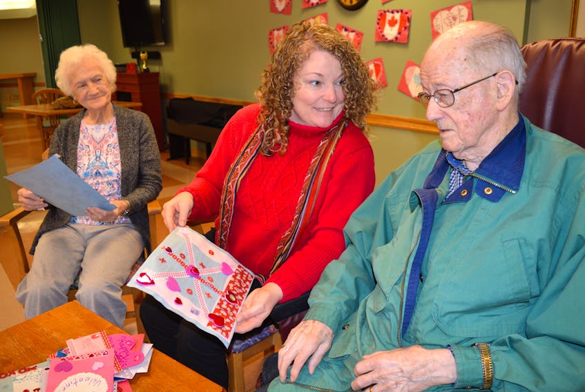 Tracy Wilson, centre, program assistant for the Cape Breton Regional Library, hands out handmade valentines to veterans at Taigh Na Mara including Mayme MacSween, left, and Arnold Jessome. The Reserve Mines and Dominion libraries hosted the Valentines for Veterans project.