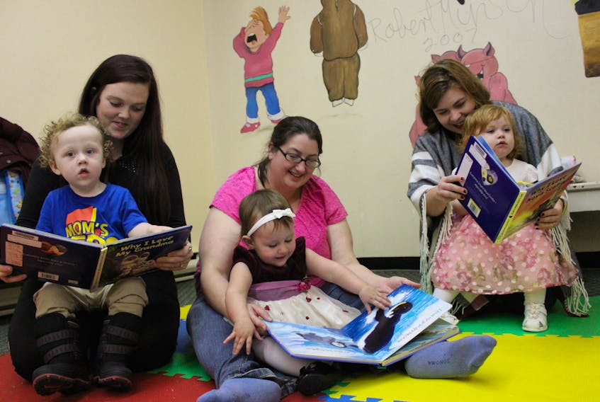 From left, babies Cohen McGillivary, 17 months, Kyra Glover-Jewells, 15 months, and Athena Brewer, 20 months, enjoy reading some books with their mothers during a Babies and Books group held at the Glace Bay Library on Nov. 7. The moms, from left, Jess Kaiser, Darlene Glover and Chelsey Wilson, all say the group has benefited them as well as their babies and they’ve now started hanging out together outside of the bi-weekly storytelling sessions.
