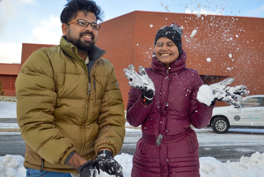 Alen Joe Francy, left, and Sethu Sugathan toss some snow in the air at Cape Breton University on Thursday. The two students from southwestern India experienced snow for the first time on Tuesday, describing it as “dripping something like wool.” CBU now has so many international students from countries with warm climates that the university organized a special coat drive called Welcome to Winter.