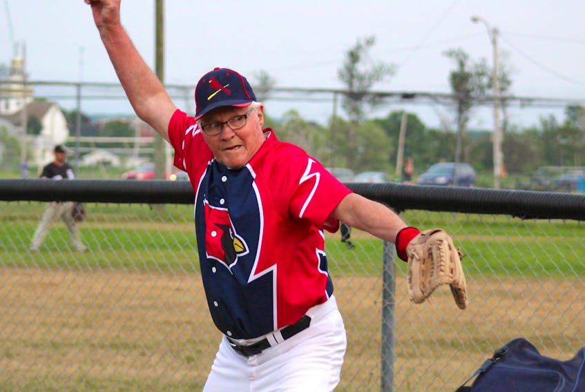 Kenny Timmons of the Chants Funeral Home Cardinals fastball team, warms up with other players prior to a recent game at the Neville Park Ballfield in Whitney Pier. Timmons said after 67 years of playing ball he has no plans to hang up his glove.