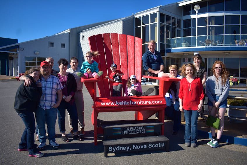 Staff and Family from Keltic Furniture try out the big red chair on Sydney's waterfront. From left are Jasmin MacPhee, Rick MacPhee, Tim Keough, Anne Marie Snow, Chris McPhee, Shenae MacPhee, Henry Crnic, Kaylee MacPhee, Ken McPhee, Donna McPhee, Chantel Crnic, Jacqueline McPhee and Kate Roberts. Missing from photo:  Alexandra O'Donnell, Michele MacInnis-Darling, Glen Campbell, Andrew Howell, Riley Williams, Kelvin Cabot and Lee Ferguson.