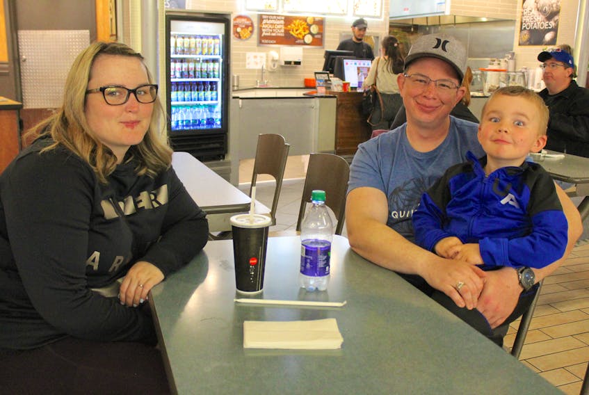Brittany McDougall, from left, Chris Poirier and their four-year-old son Declan Poirier sit in the Mayflower Mall food court on Sunday after finishing lunch. Single-use plastics like the cup, lid and straw in front of McDougall are some of the items the federal government is planning to have banned by 2021. Although the family isn’t fond of paper straws, which they find start to fall apart while using them, McDougall and Poirier agree it’s a move that will help eliminate plastic litter and be better for the environment.