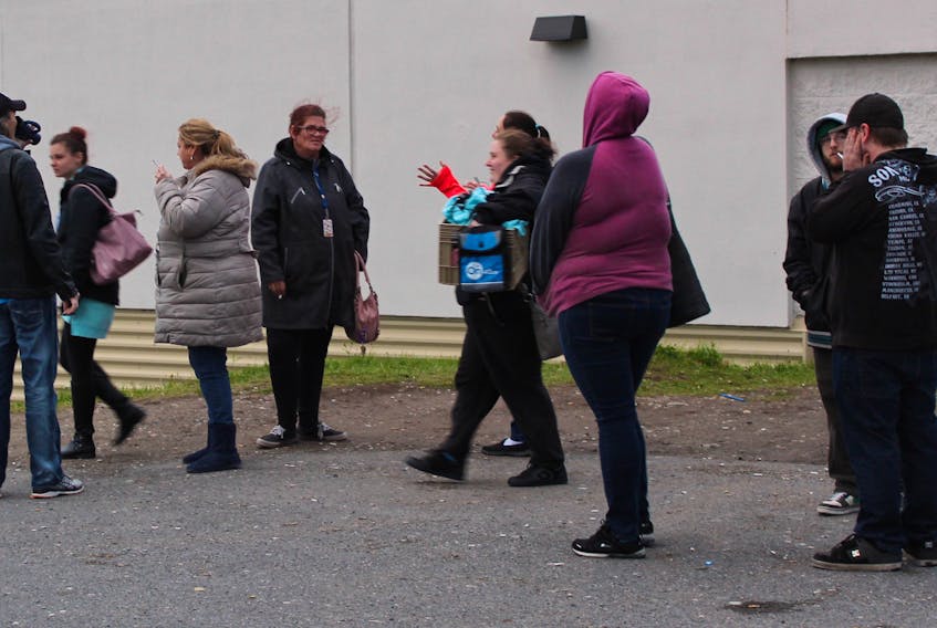 Employees of ServiCom Canada Ltd. call centre in Sydney leave the building on Dec. 6 after being told the business was shutting down.