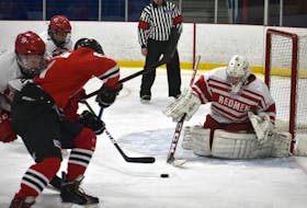 In this file photo, Michael MacMullen of the Riverview Redmen, right, prepares to poke-check the puck during Cape Breton High School Hockey League action earlier this year at the County Recreation Centre in Coxheath. Riverview will be removing the name "Redmen" from its hockey program as the school prepares to re-brand its sports team names.