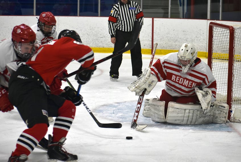 In this file photo, Michael MacMullen of the Riverview Redmen, right, prepares to poke-check the puck during Cape Breton High School Hockey League action earlier this year at the County Recreation Centre in Coxheath. Riverview will be removing the name "Redmen" from its hockey program as the school prepares to re-brand its sports team names.