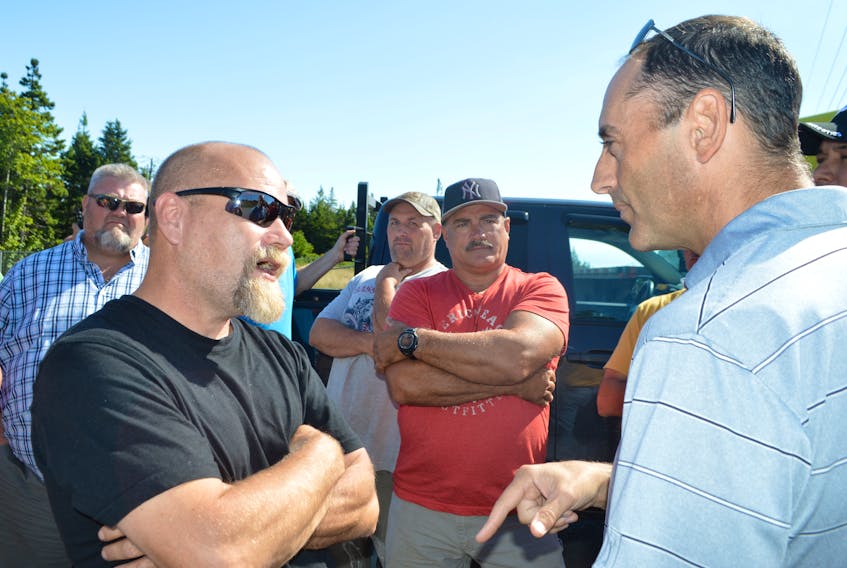 Port Morien fisherman Don Messenger, left, talks to Donkin Mine vice president Shannon Campbell during a protest which saw fishermen block the entrance to the mine on Tuesday. Messenger said there are no viable options, he wants the mine to close before it destroys their fishery.