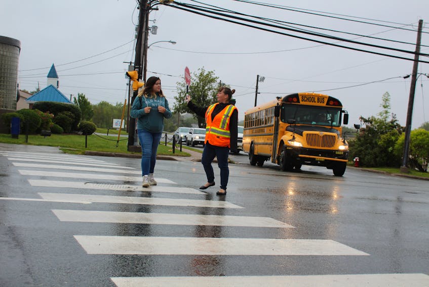 Crossing guard Tracey Bonner, right, leads her daughter Melissa Agnew across Prince Street, Sydney, on Wednesday morning.