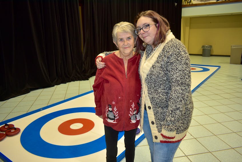 Mary Kay, left, and daughter Chantelle MacKeigan stand for a picture near a curling rink display during the Scotties Tournament of Hearts open house at Centre 200 on Nov. 14. Kay will be among close to 380 volunteers when the Scotties tournament comes to Cape Breton in February.