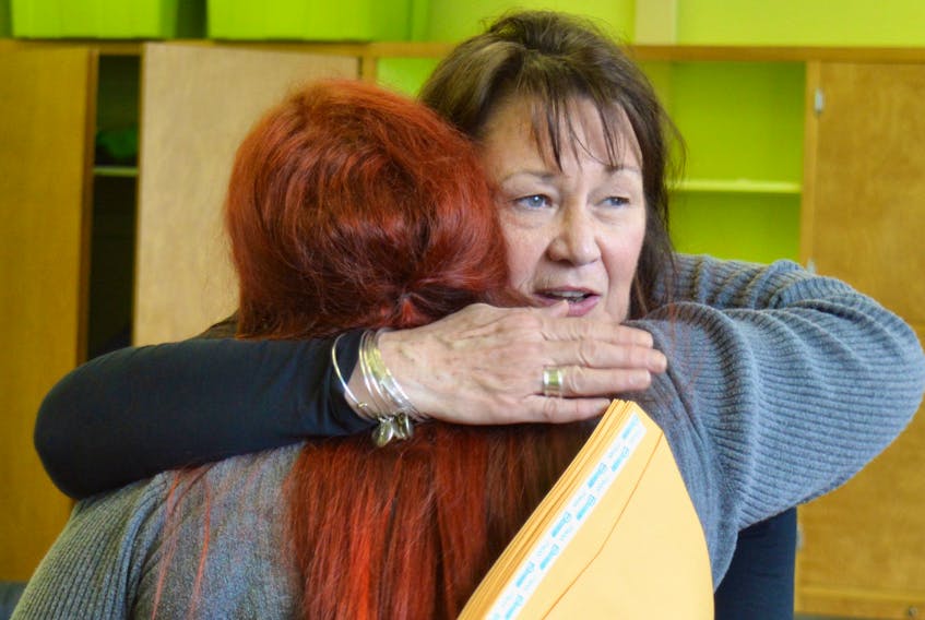 Ann McPhee, workplace co-ordinator with the Ann Terry Society, gives Jenna Wall a hug after Wall completed the society’s women’s transition to employment program on Thursday.