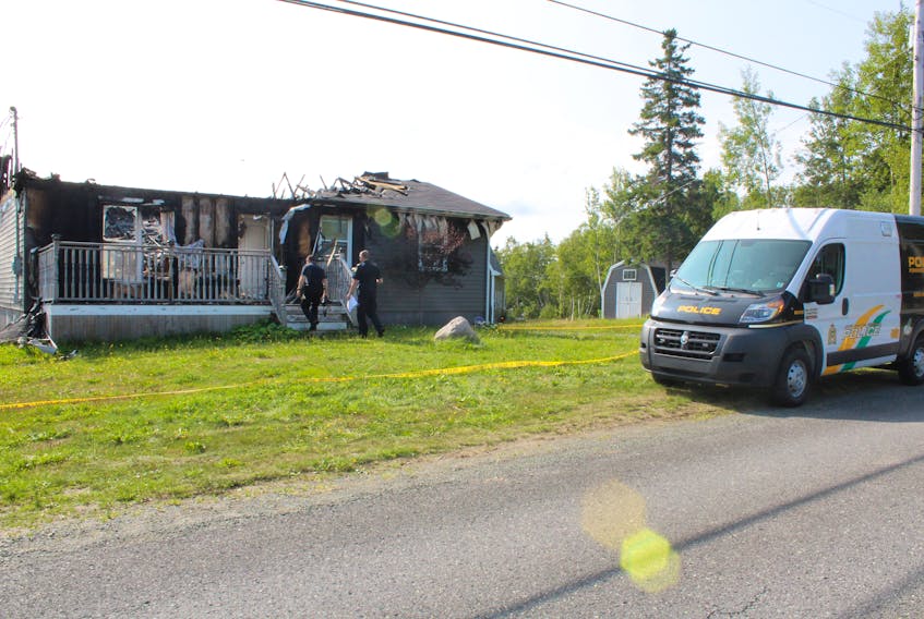 Cape Breton Regional Police Service investigators are shown outside of a home on Point Aconi Road on Monday morning. A fire on Saturday caused extensive damage to the home.
