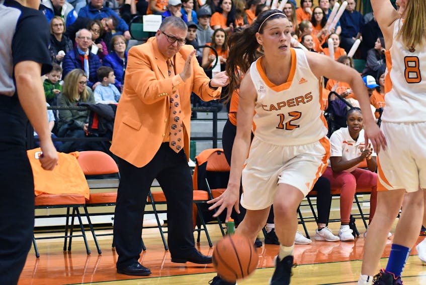 Cape Breton Capers women’s basketball head coach Fabian McKenzie encourages his players while Alison Keough of Marion Bridge drives to the hoop during Atlantic University Sport play Saturday at Sullivan Field House. The Capers won, 88-57.