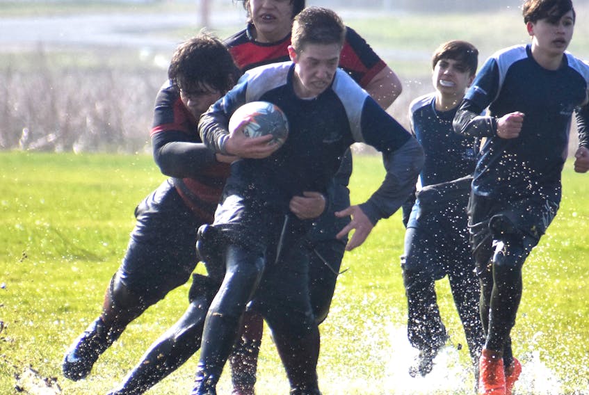 Dawson MacNeil of the Sydney Academy Wildcats runs the ball as he’s tackled by Jonathan Roach of the Glace Bay Panthers during the Highland region boy's rugby championship game Wednesday at Hub Field in Glace Bay. The Panthers won the game 54-0 and will play in the provincial championship later this month.