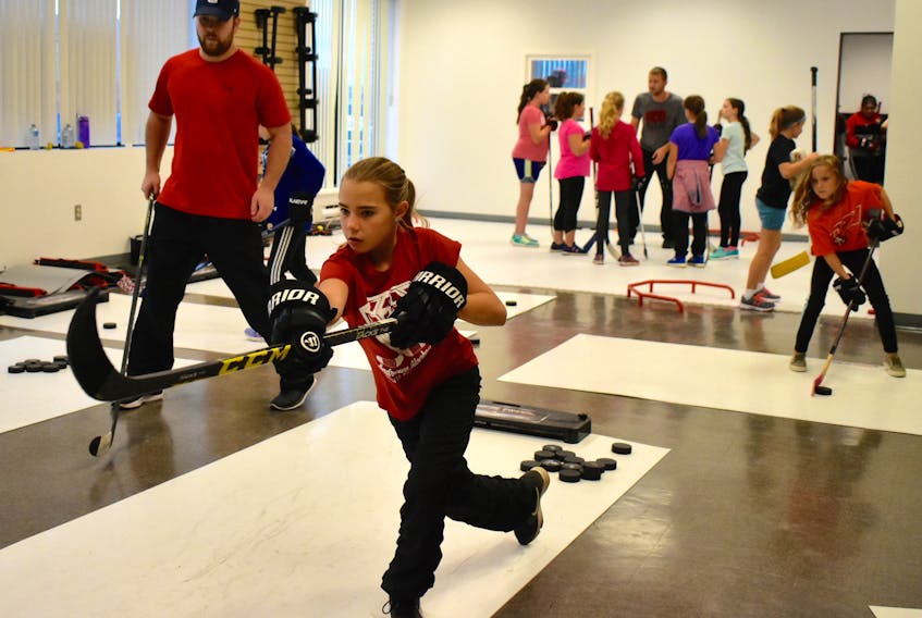 Vada Kennedy demonstrates her shooting technique as ECO Hockey Skills Development coach Kenzie Wadden looks on. Kennedy was recently training at the downtown Sydney facility along with other members of the Cape Breton Atom “A” Blizzard hockey team. The new centre offers off-ice hockey skills training in a safe and fun environment.