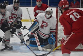Dustin Sudds of the Riverview Redmen looks to make a play at the side of the Glace Bay goal as Panthers goaltender Coady Smith and his teammates look on during Cape Breton High School Hockey League playoff action at the Canada Games Complex on March 6, 2018.