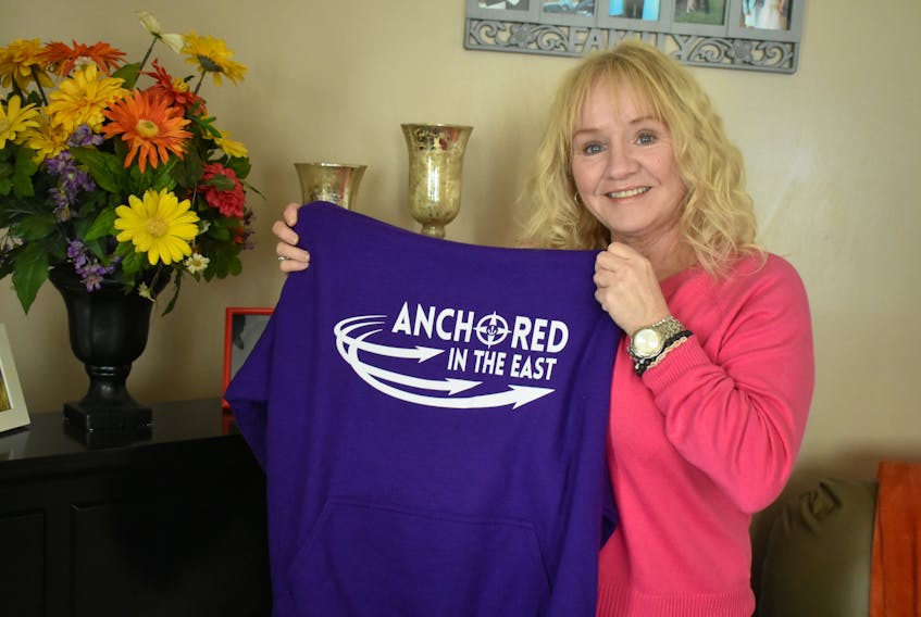 Patricia McDougall, owner of Anchored in the East, holds a sweatshirt from the clothing line. The New Waterford native launched the business on Oct. 31 and plans to donate a portion of each sale to a mental health initiative.