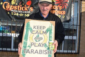 Angus Capstick, owner of Capstick's Novelties and More, holds some of the tarabish-related items he sells at his Liberty Street wholesale store.