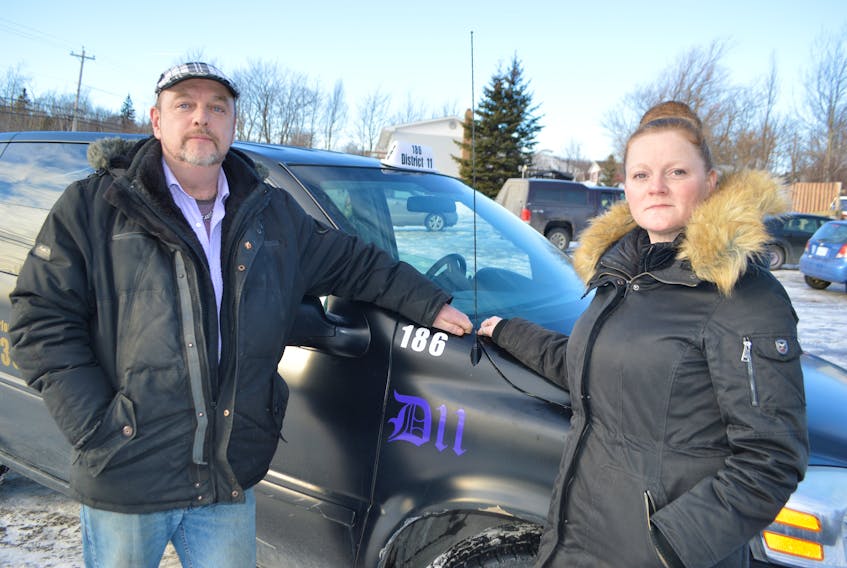 Chuck Ogley and Elizabeth Doyle, both of New Waterford, stand by one of their taxi cabs at their depot in River Ryan. Ogley said they are trying to get their new business running but are being harassed by the CBRM bylaws officers. Officials with the CBRM say the company simply isn’t adhering to the taxi bylaws.