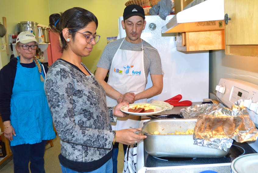 Ruchika, centre, a native of India, is a business management student at Cape Breton University and a volunteer in the kitchen at the Glace Bay Food Bank. On Friday, she was assisted in the kitchen by Kimberly McPherson, garden co-ordinator, and Joe Machalik, the full-time cook. Ruchika, who only uses one name, said she is volunteering at the food bank so she can help people.
