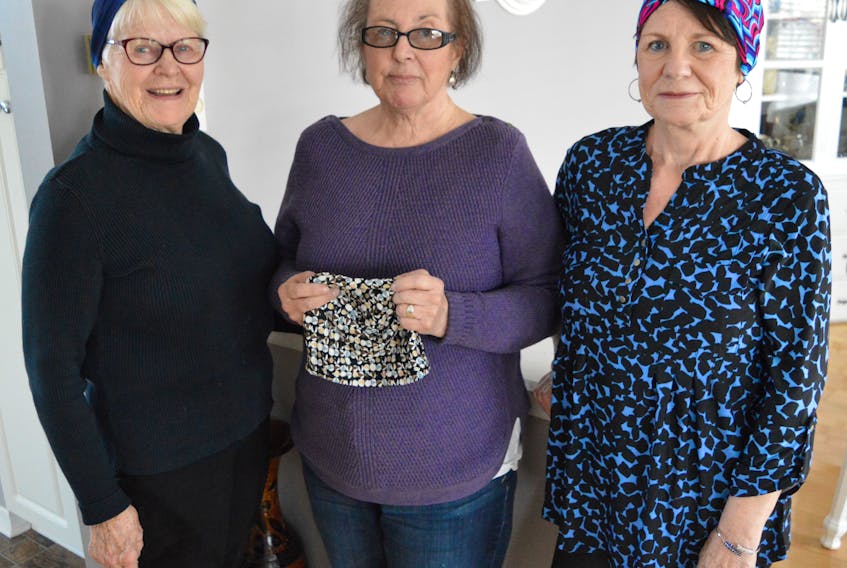 From left, Kathleen Jerrot, Linda Prendergast and Liz Peach model some of the head coverings they’ve made with the Homeville Women’s Institute to give to women going through cancer treatments.
