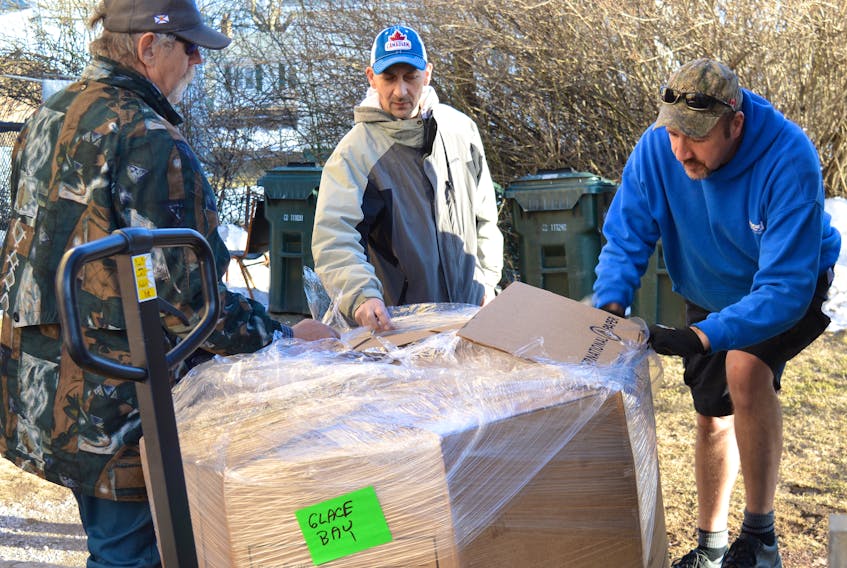 Glace Bay Food Bank volunteers, from left, Tom Dwyea and Joey Michalik, help Mike Jack of Halifax unload 500 pounds of mussels from the Feed Nova Scotia truck, which arrived Thursday. An increase in clients has moved the food bank into a higher poverty category and as a result they now receive more food from Feed Nova Scotia.