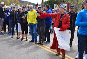 Dressed as a lobster, her team’s mascot, Jillian Thomas stretches out her hand in hopes a runner will hit her “claw” as they make it to the finish line. The 12-year-old has been coming with her mother to cheer on their team since she was four.