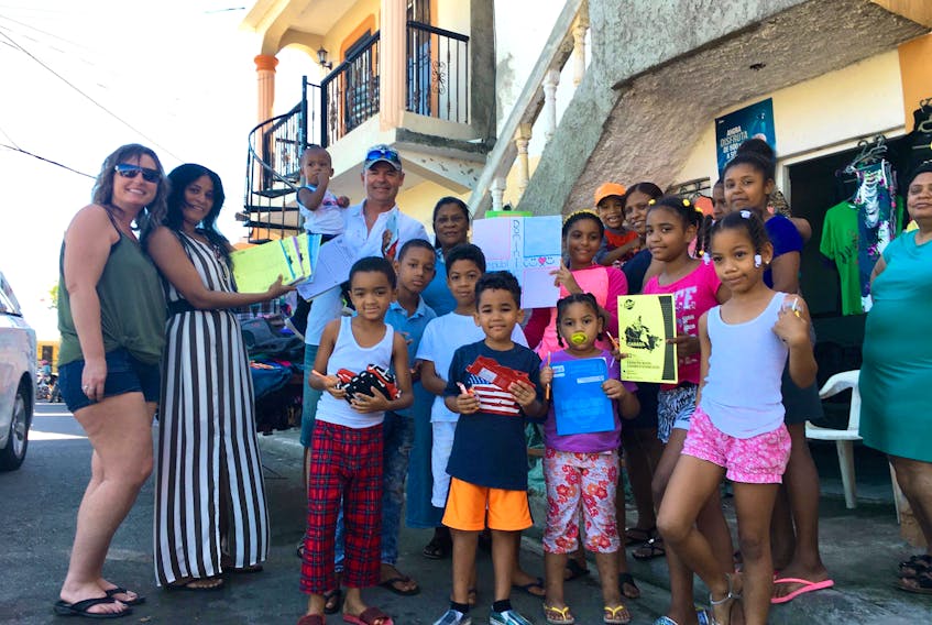 Adena McLean, left, and her husband Brad McLean and youth worker Santa Rodriguez, second from left, are joined by a group of children at a youth program in Puerto Plata, Dominican Republic, during the couple’s trip to the Caribbean country in January.