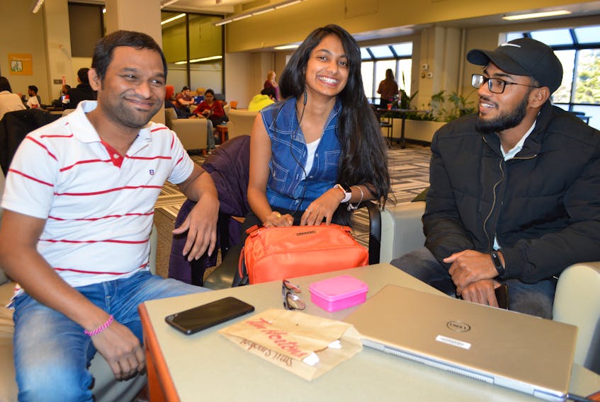 From left, friends Bobige Babu, 35, Sravani Mogadari, 20, Sandeep Reddy, 22, of India, who all arrived in Cape Breton in December and are all studying towards their degrees in supply chain management at Cape Breton University, chat during a break in classes Wednesday. The friends say it has been four months and they still can’t find jobs, making it difficult to get by. All three say they will be attending the summer job expo at the Great Hall at CBU on Friday.