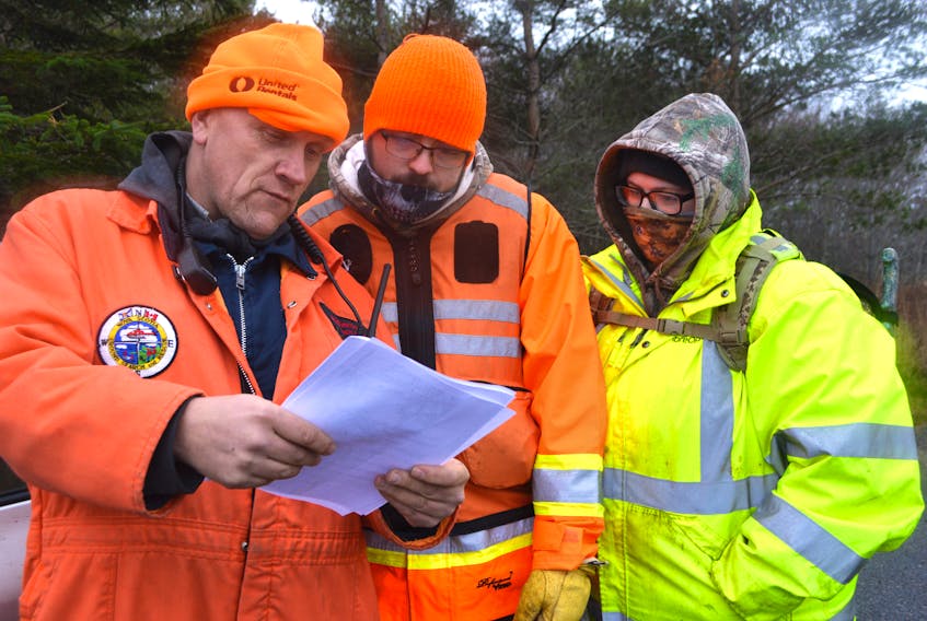Members of Cape Breton Search and Rescue including, from the left, Dougie Hooper, team leader, Cody Bellefontaine and Whitney MacNeil, look over information while gathered at their command post behind the New Waterford Consolidated Hospital Tuesday afternoon, during a search for David Gerard Simmons, 64, of Glace Bay. Family of Simmons last heard from him Nov. 13 and he was last seen on Nov. 15 in New Waterford.
