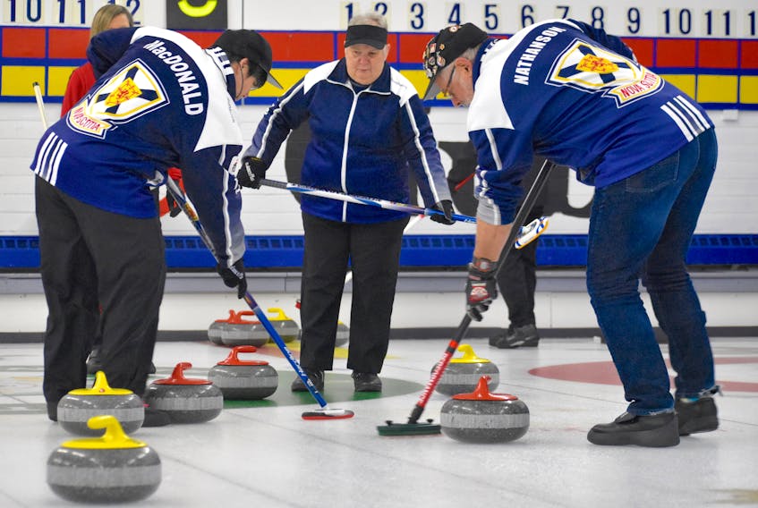 Louise Gillis, centre, watches as teammates Terrylynn MacDonald, left, and Garth Nathanson sweep the stone into the house during house curling league action Monday at the Sydney Curling Club. Despite being almost completely blind, Gillis, 70, remains active, skipping her own curling team, volunteering with the Special Olympics and paddling with a local dragon boat club.