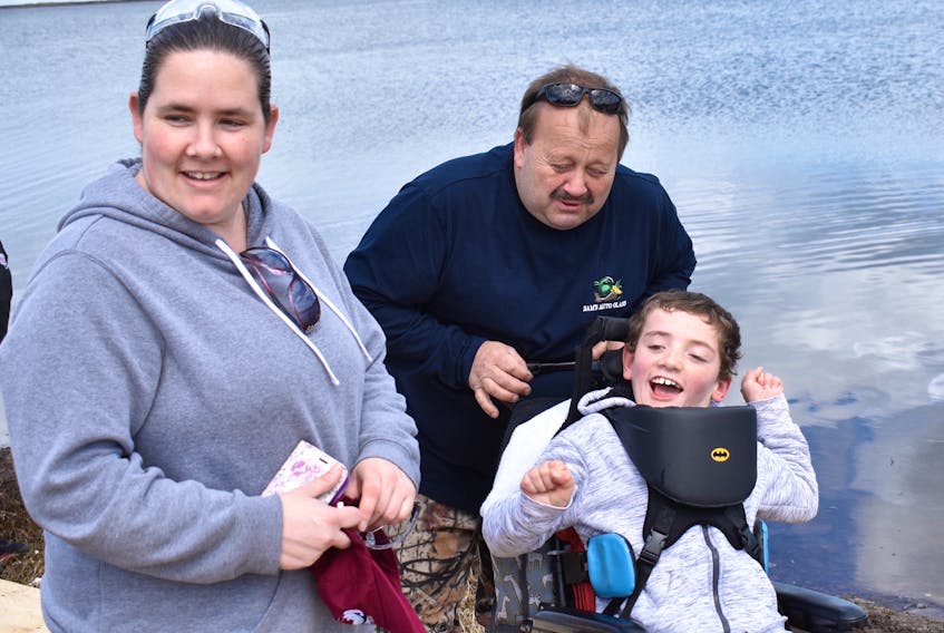 Devon MacNeil expresses his delight at being involved in Sunday’s learn-to-fish event that was held at Big Pond in Sydney Mines. Volunteer Freddy Anderson is shown pushing Devon, while the 10-year-old’s mother Nichol MacNeil looks on during the afternoon event that saw a number of local organizations, including the Sydney Mines Volunteer Fire Department, come together to introduce kids with a connection to the pediatric ward of the Cape Breton Regional Hospital to fishing.